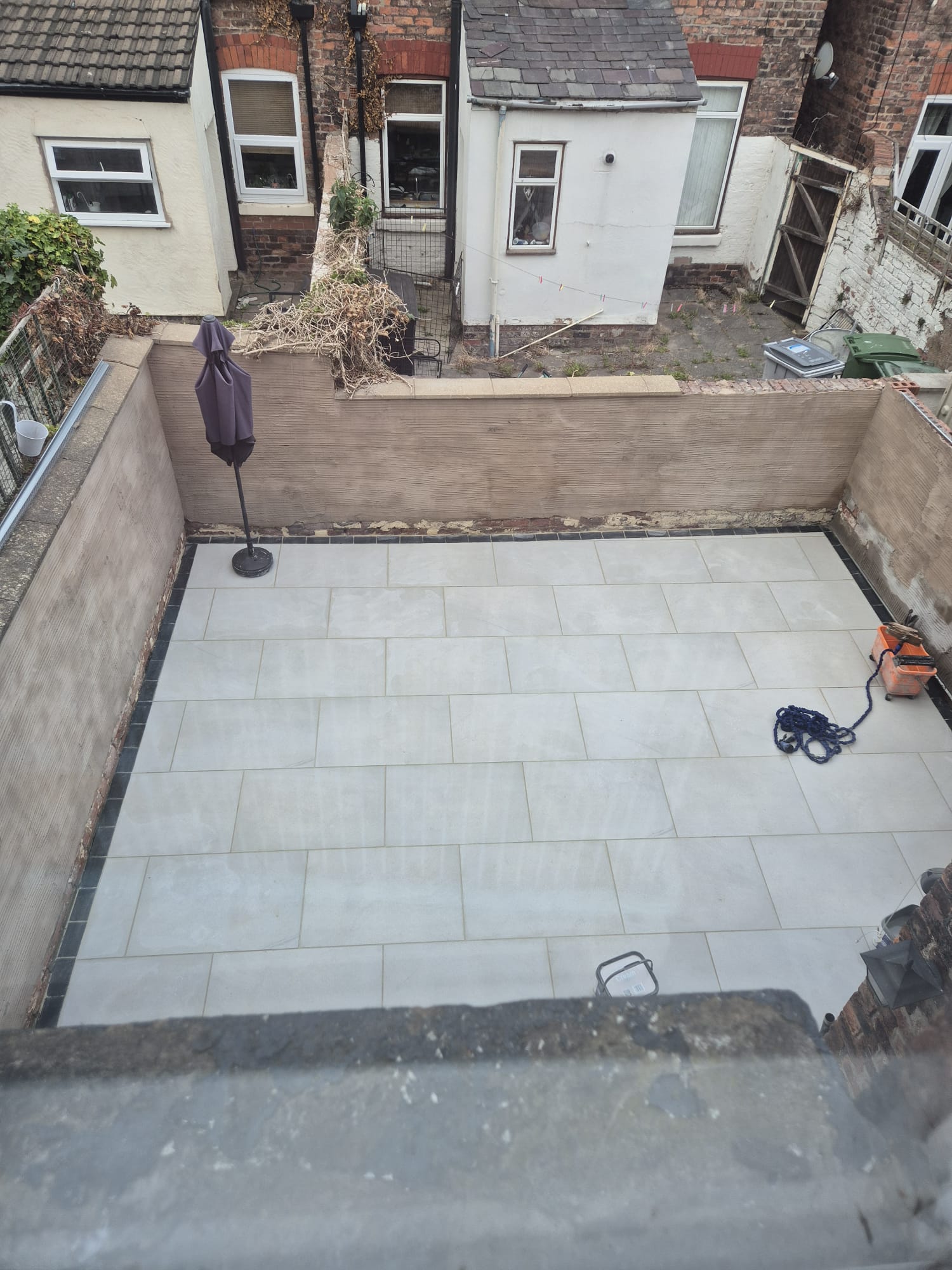 Newly completed grey porcelain patio in a Wirral back yard, viewed from above